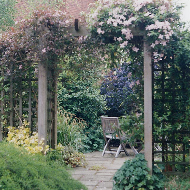 A small courtyard garden enhanced by a a timber arch